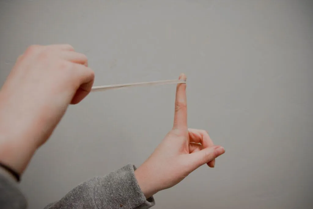 A stretched rubber band symbolizes muscle tension and strain, highlighting the importance of visiting a local chiropractor for relief and improved flexibility.