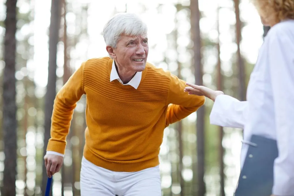 An elderly man experiencing back pain seeks relief and support from a local chiropractor for improved mobility and comfort.
